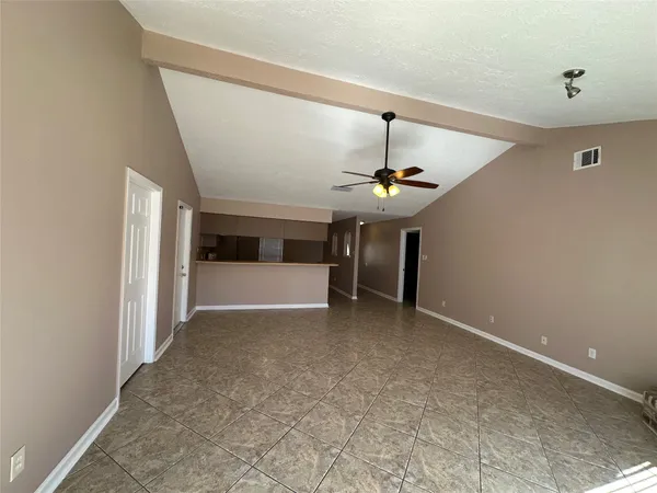a view of a room with a ceiling fan and window