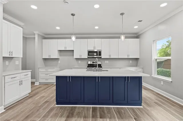a kitchen with kitchen island sink stove and cabinets