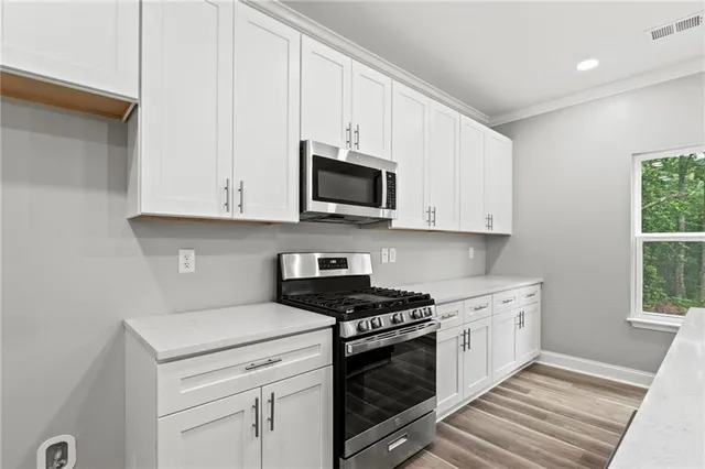 a kitchen with granite countertop white cabinets and white appliances