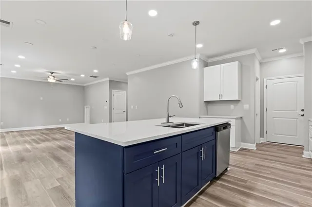 a kitchen with a sink chandelier and wooden floor