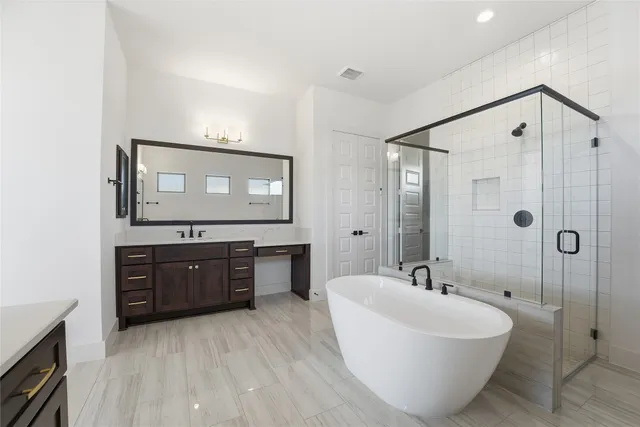 a spacious bathroom with a tub sink mirror and a shower