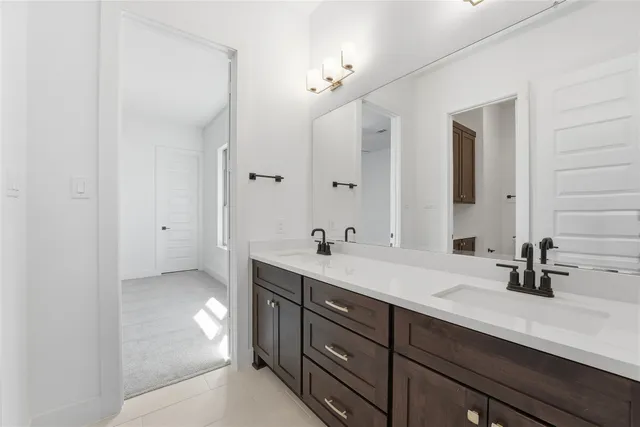 a spacious bathroom with a double vanity sink a mirror and a bathtub