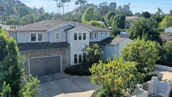 a aerial view of a house with a yard and potted plants
