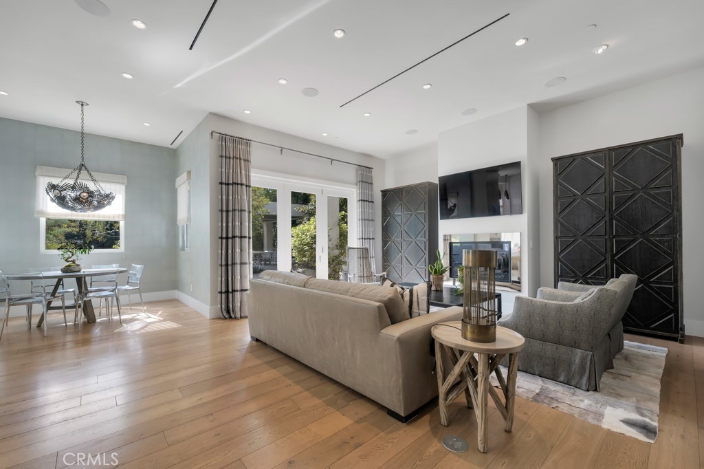 17950 Rancho Street Encino, CA 91316 - Photo 12 of 75 a living room with furniture a fireplace and a flat screen tv