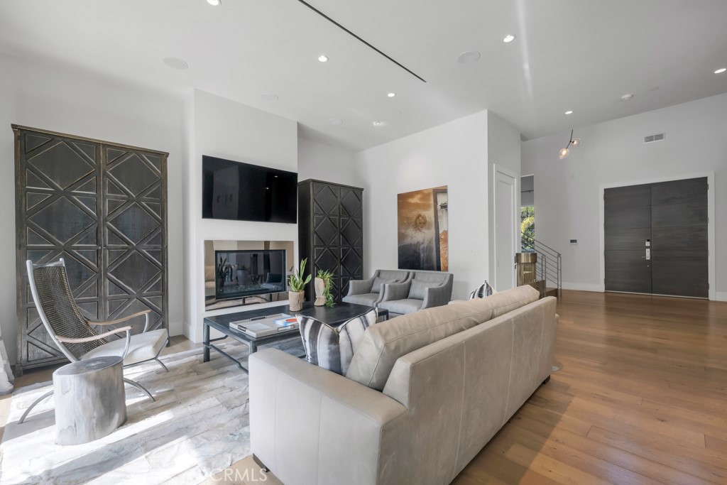 17950 Rancho Street Encino, CA 91316 - Photo 14 of 75 a living room with furniture a fireplace and a flat screen tv