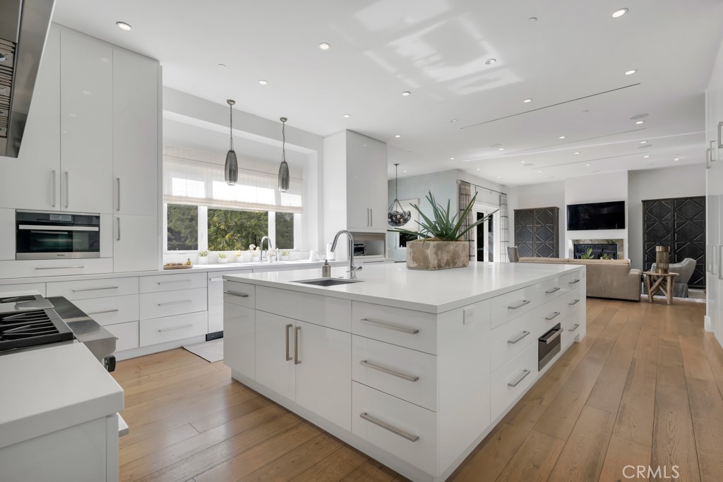 17950 Rancho Street Encino, CA 91316 - Photo 24 of 75 a large white kitchen with a large window and stainless steel appliances