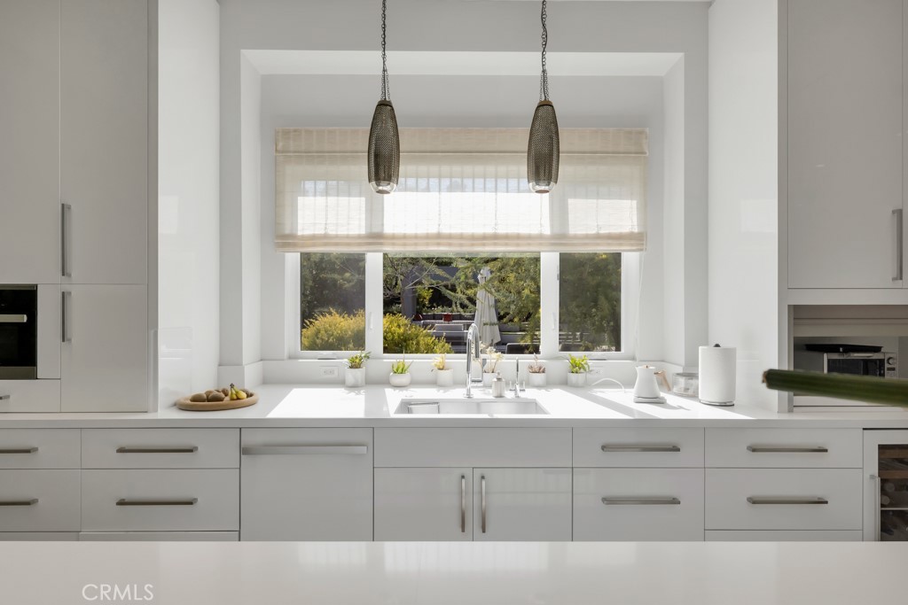 17950 Rancho Street Encino, CA 91316 - Photo 25 of 75 a bathroom with a sink and a large mirror next to a window