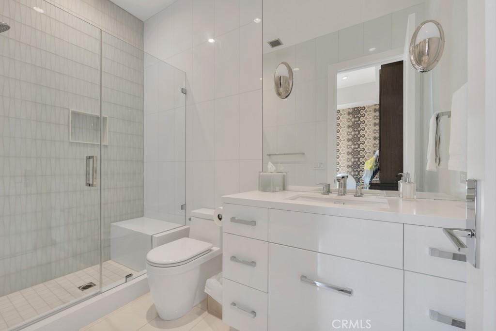 17950 Rancho Street Encino, CA 91316 - Photo 30 of 75 a bathroom with a toilet sink a mirror and shower