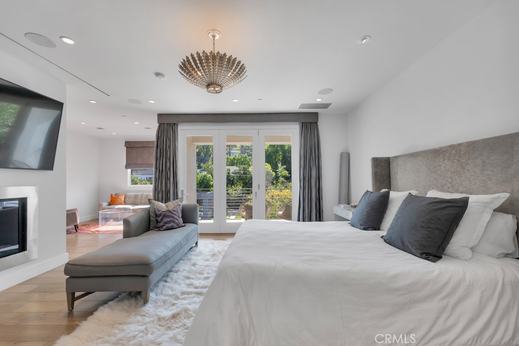 17950 Rancho Street Encino, CA 91316 - Photo 39 of 75 a bedroom with a bed and a chandelier