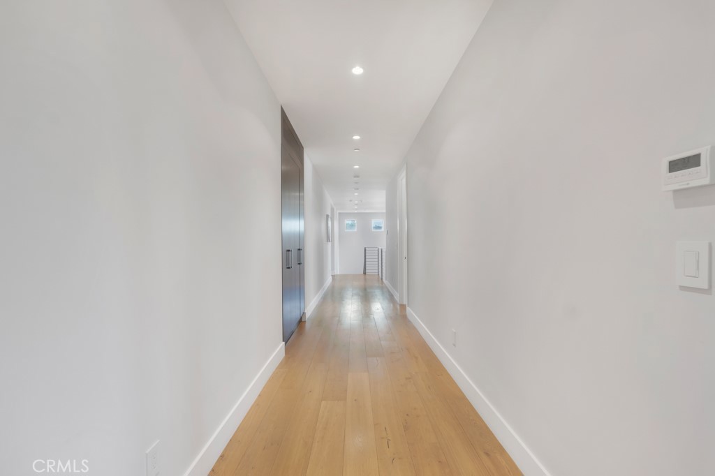 17950 Rancho Street Encino, CA 91316 - Photo 53 of 75 a view of a hallway with wooden floor