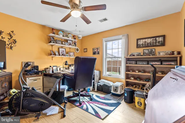 a view of a workspace with furniture and a window