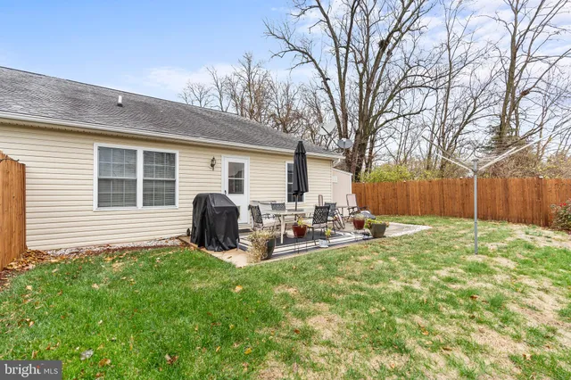 a view of a house with backyard and chairs