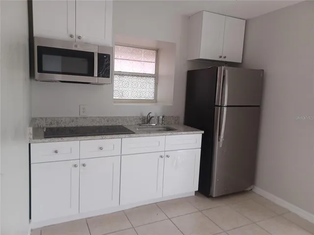 a kitchen with a refrigerator sink and microwave
