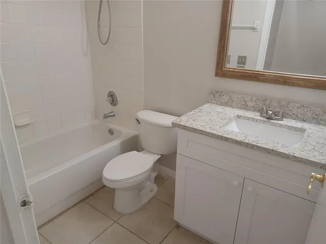 a bathroom with a granite countertop toilet sink and mirror