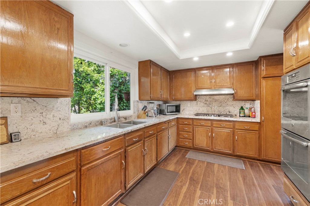 7125 Lonzo Street Tujunga, CA 91042 - Photo 16 of 66 a kitchen with granite countertop stainless steel appliances a sink window and cabinets