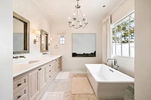 a bathroom with a double vanity sink a mirror and a bathtub