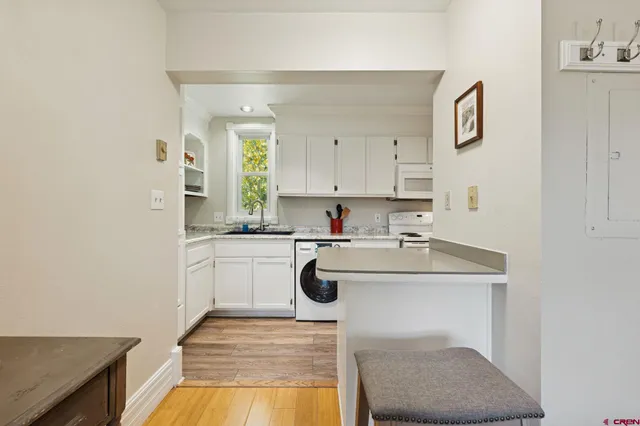 a kitchen with stainless steel appliances granite countertop white cabinets and a sink