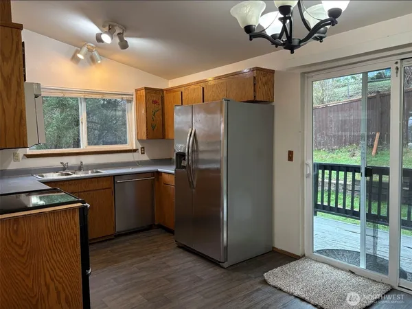 a kitchen with stainless steel appliances granite countertop a refrigerator a sink and dishwasher