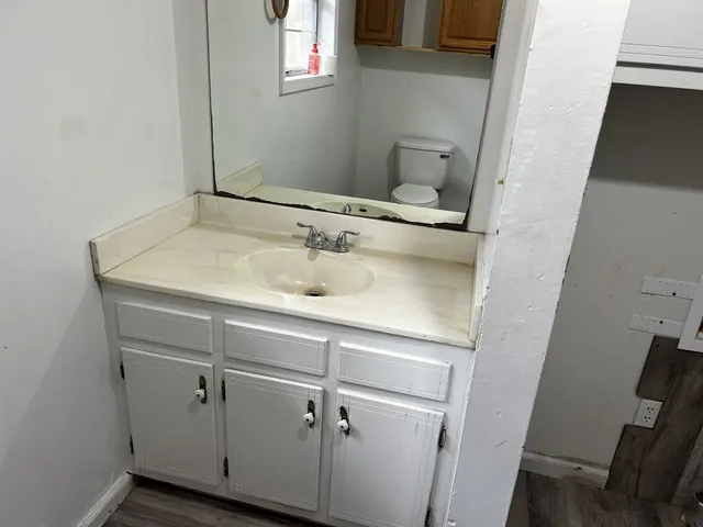 a view of a sink a mirror and cabinets in a room