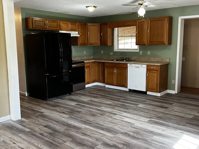 a kitchen with granite countertop a refrigerator and a sink