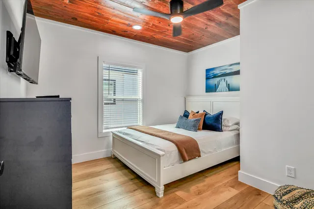 a bedroom with a bed and wooden floor