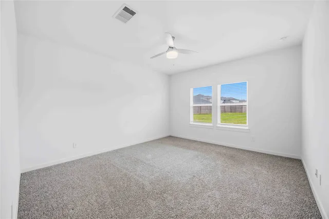 an empty room with a window and a ceiling fan