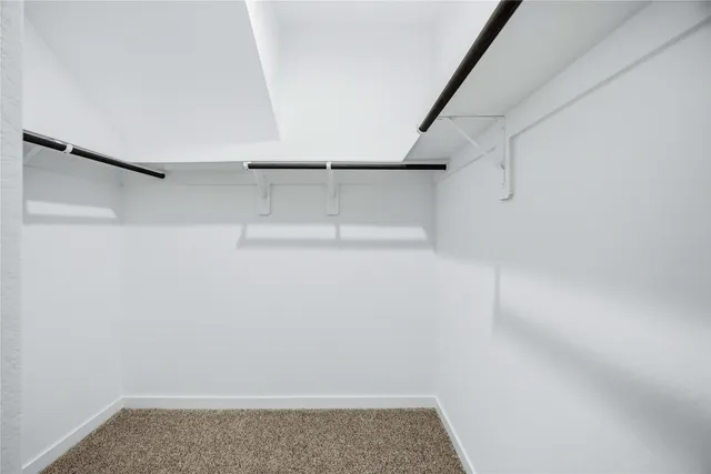 a view of walk in closet with empty racks