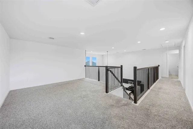 an empty room with wooden floor and stairs
