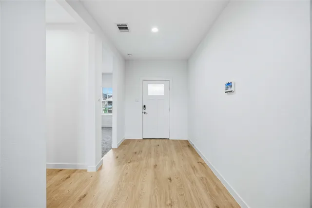 a view of a room with wooden floor and white walls