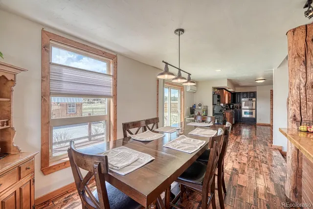 a view of a dining room and livingroom view with furniture wooden floor a chandelier