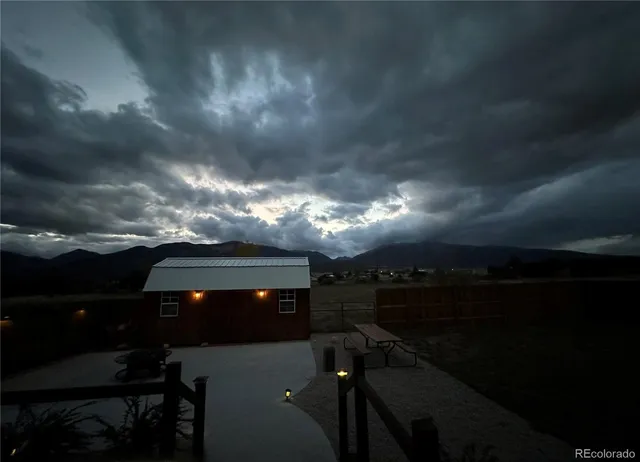 a view of a house with a yard and a large tree
