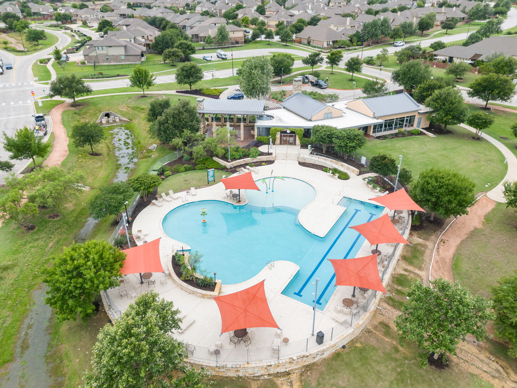 440 Cherokee Rose Circle Georgetown, TX 78626 - Photo 36 of 39 An aerial view showcases a vibrant community pool with ample recreation space, nestled within a charming neighborhood.