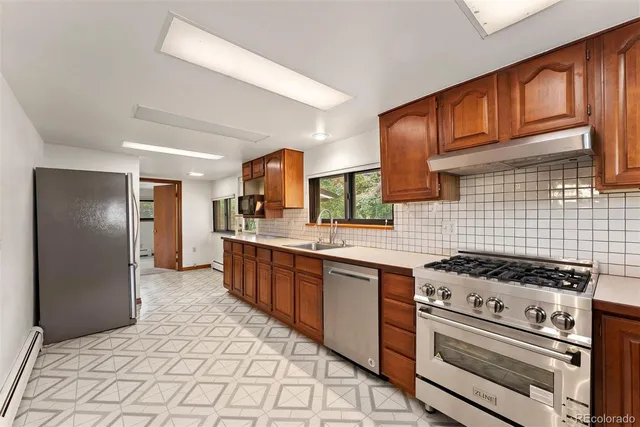a kitchen with stainless steel appliances granite countertop a stove a sink dishwasher and refrigerator