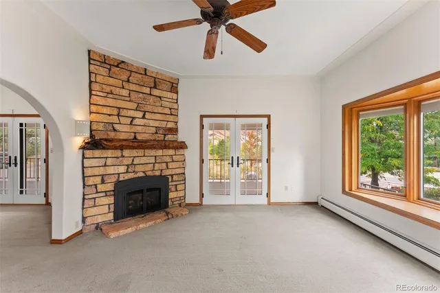 a view of an empty room with a fireplace and a window