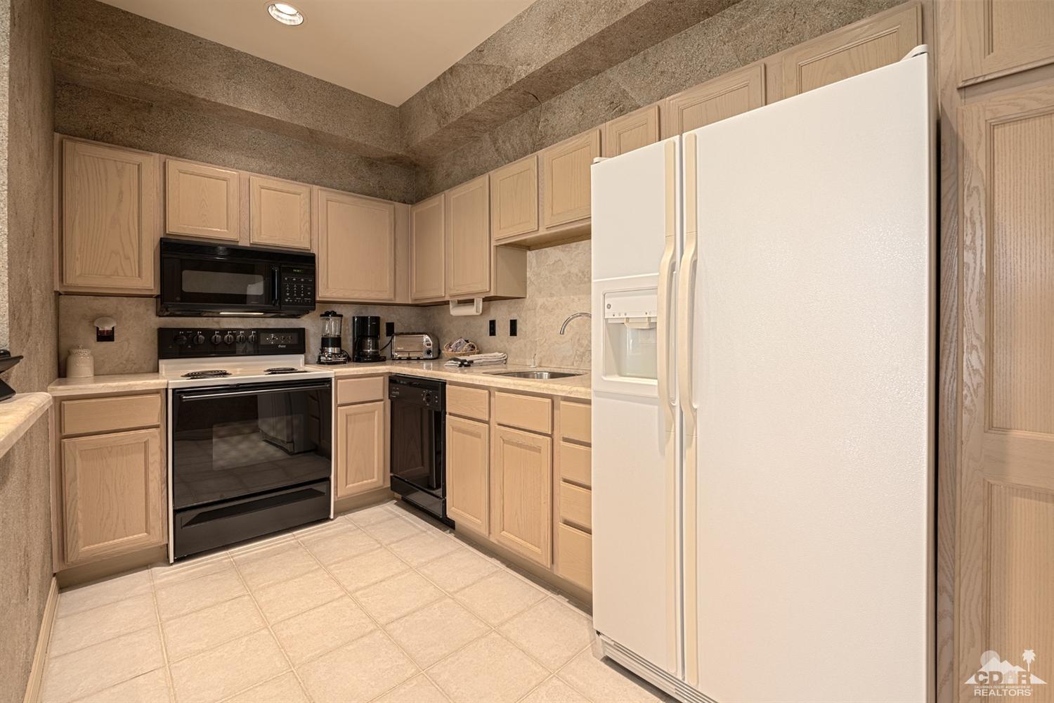 70375 Thunderbird Road Rancho Mirage, CA 92270 - Photo 37 of 54 a kitchen with a stove sink and a refrigerator