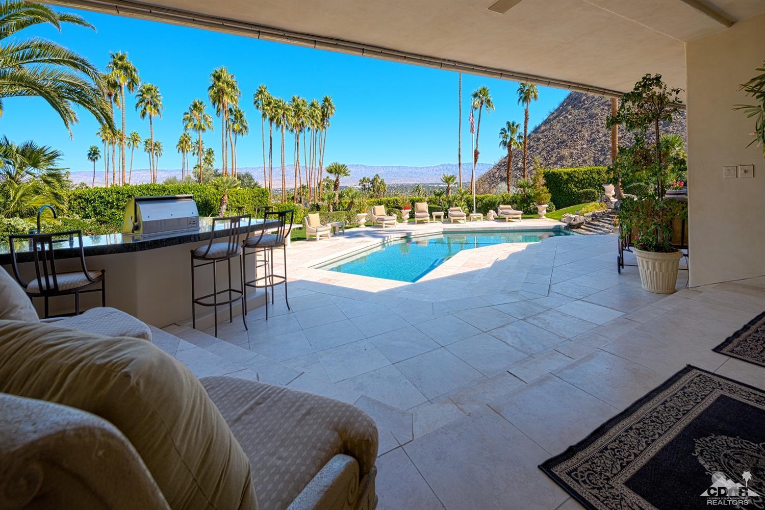 70375 Thunderbird Road Rancho Mirage, CA 92270 - Photo 42 of 54 a view of a swimming pool with a patio and a yard