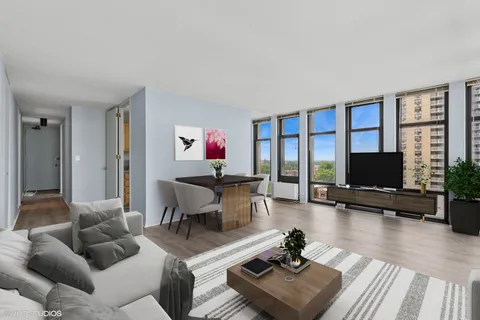 a living room with furniture flat screen tv and a large window