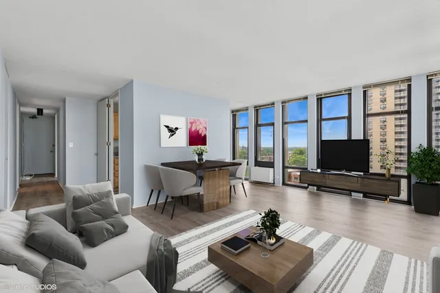 a living room with furniture flat screen tv and a large window