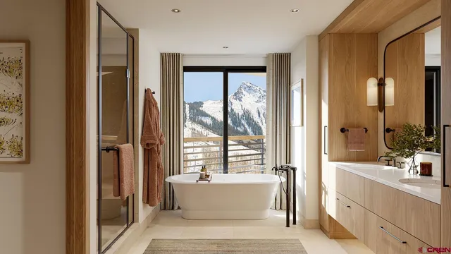 a bathroom with a tub a sink and a large mirror