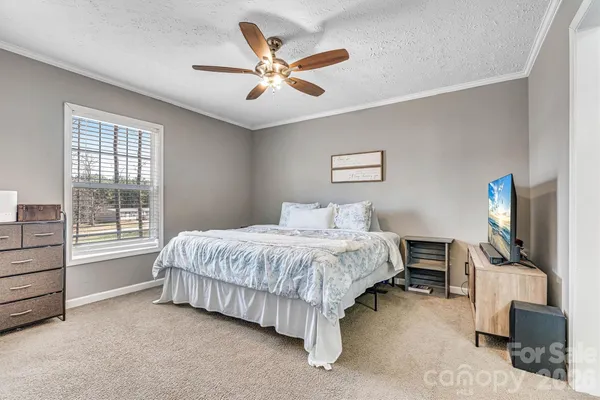 a bedroom with a large bed and a chandelier