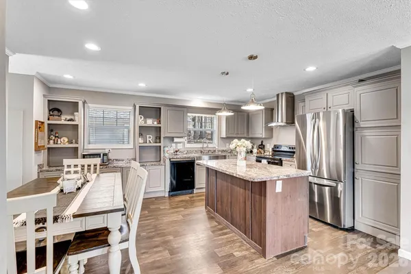 a kitchen with kitchen island a counter top space a sink appliances and cabinets