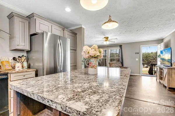 a large kitchen with a counter top space a sink stainless steel appliances and cabinets