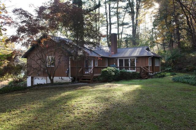 a front view of a house with a garden and trees
