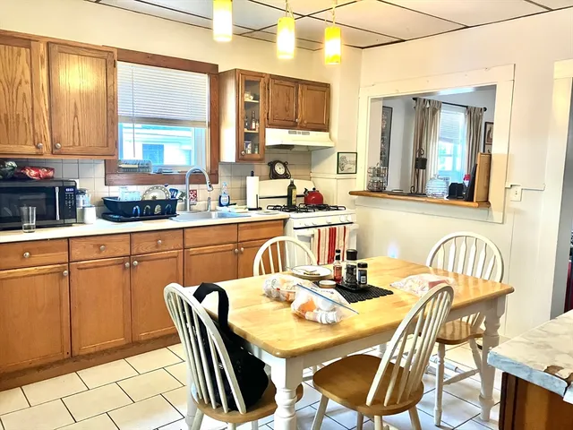 a kitchen with stainless steel appliances granite countertop a table chairs and a refrigerator