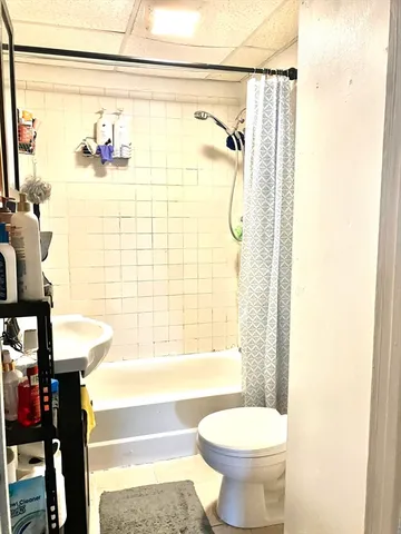 a bathroom with a toilet and a shower curtain