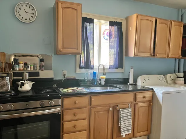 a kitchen with granite countertop a sink stove and cabinets