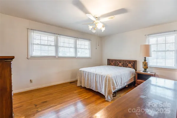 a spacious bedroom with a bed and a chandelier