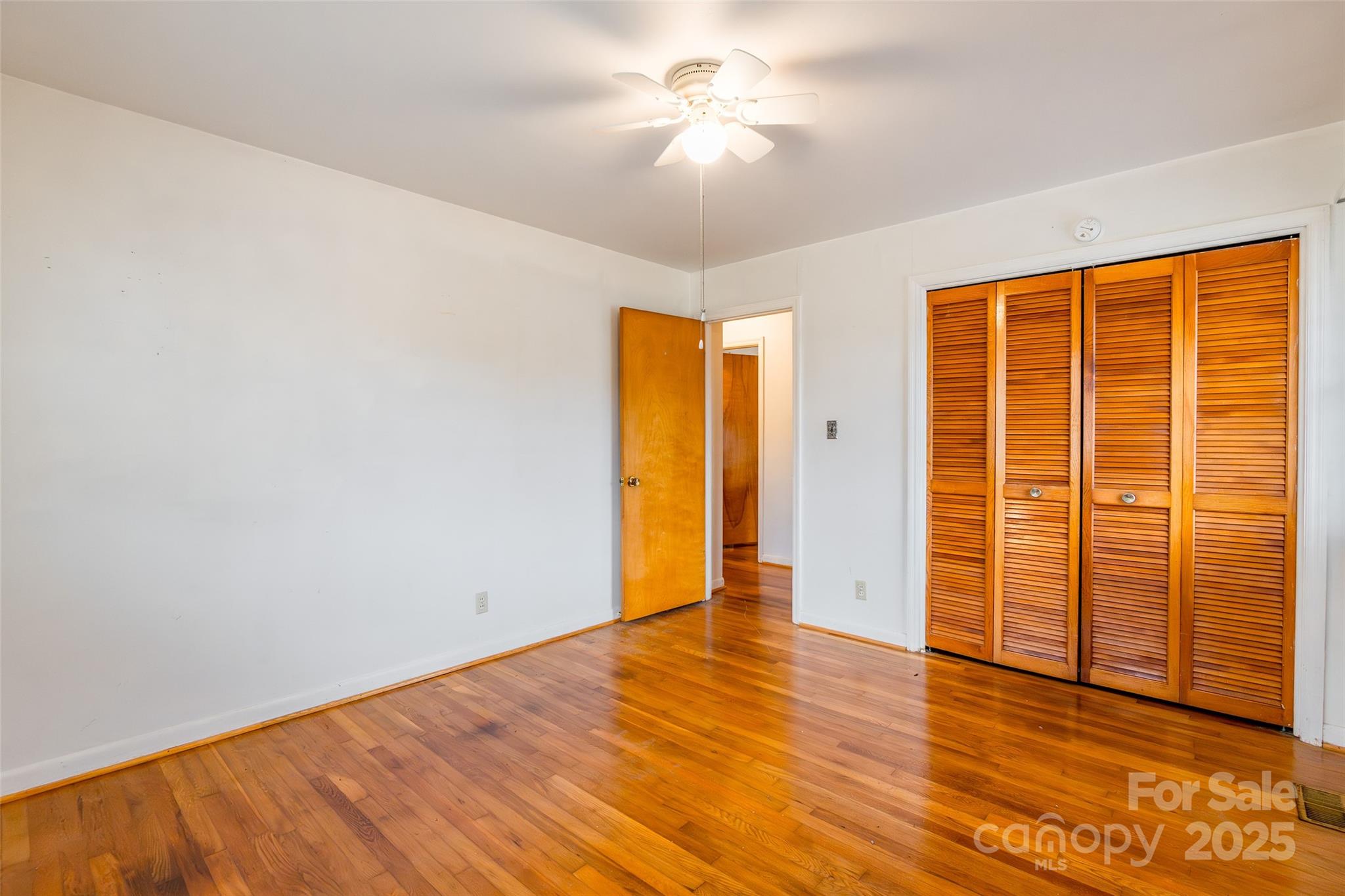 2100 J B Denton Road Lancaster, SC 29720 - Photo 23 of 44 an empty room with wooden floor and a ceiling fan
