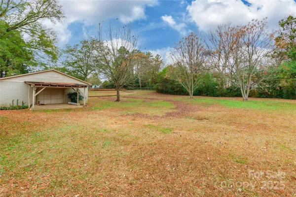 a view of backyard with wooden fence