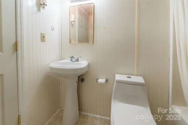 a white toilet sitting next to a bath tub